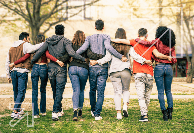 A group of people walking together with their arms around each other