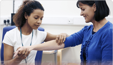 A health care professional touching  a patients arm